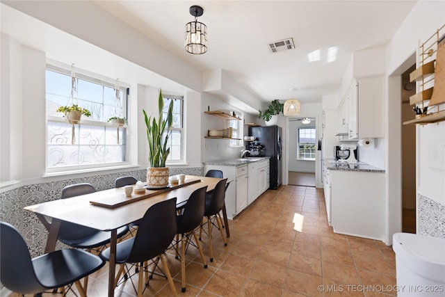 dining space featuring visible vents and light tile patterned flooring