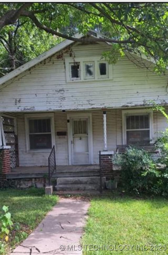 view of front of home with a porch and a front yard