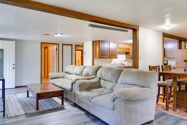 living room with visible vents, baseboards, and wood finished floors