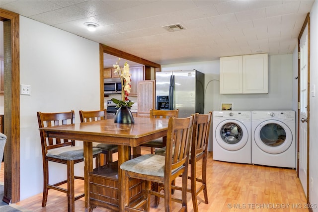 interior space featuring light wood finished floors, visible vents, and washing machine and clothes dryer