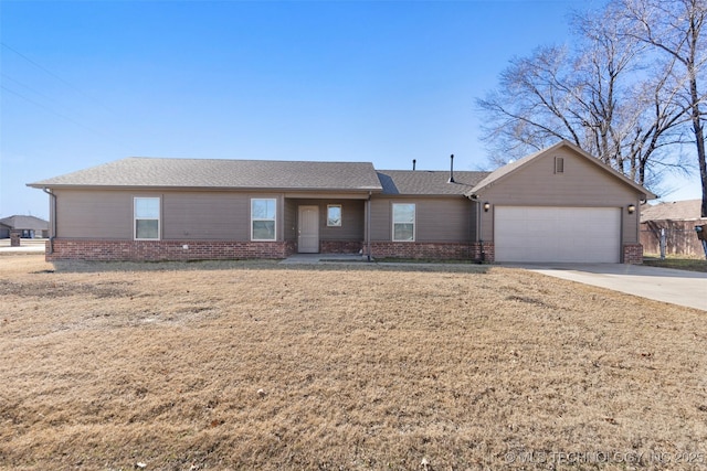 single story home with a garage, brick siding, driveway, and a front lawn