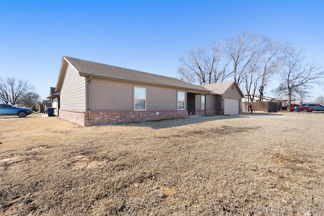 ranch-style home featuring an attached garage and brick siding