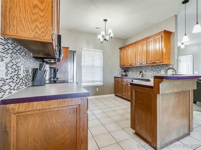 kitchen featuring a peninsula, light tile patterned flooring, decorative backsplash, and brown cabinets