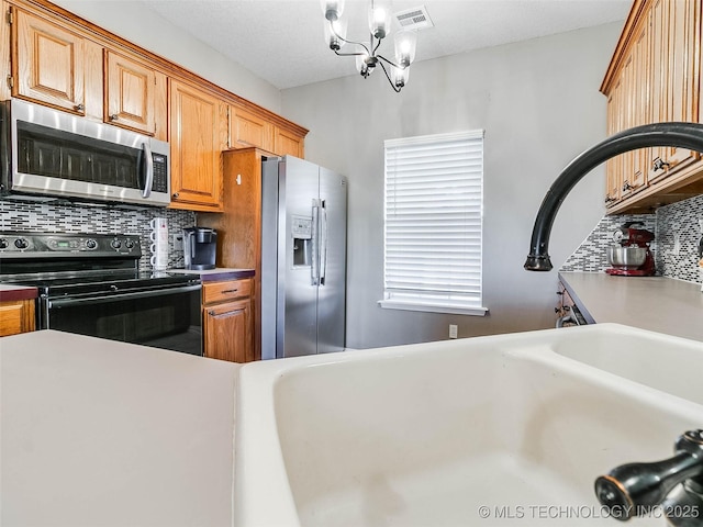 kitchen with stainless steel appliances, brown cabinets, visible vents, and decorative backsplash