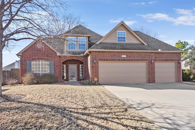 view of front of home with brick siding, roof with shingles, fence, a garage, and driveway