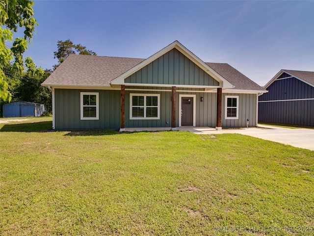 view of front of home featuring roof with shingles, a front lawn, and board and batten siding