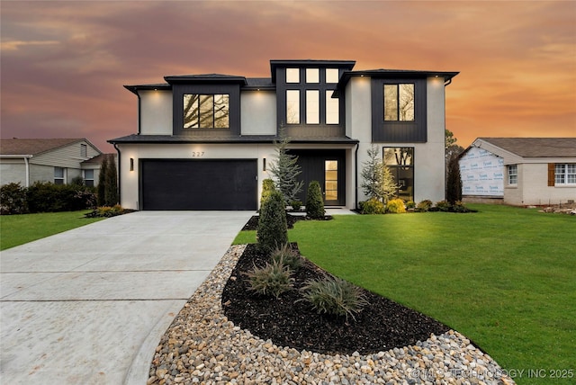 view of front of property with a garage, a front lawn, concrete driveway, and stucco siding