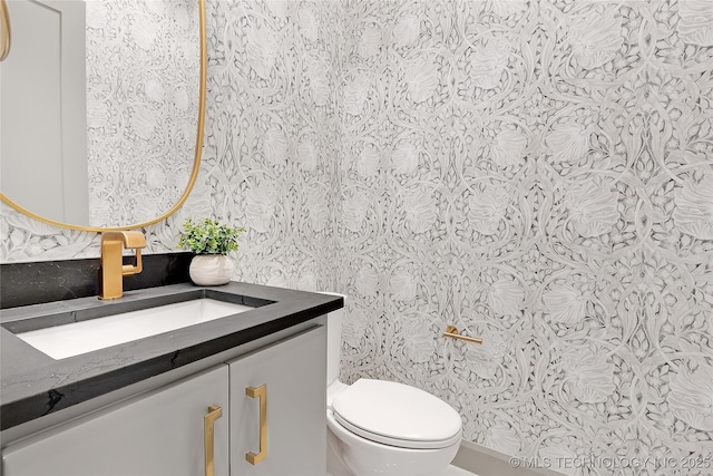 227 E 35th St, Tulsa, OK 74105 - half bathroom with wallpapered walls, vanity, and toilet