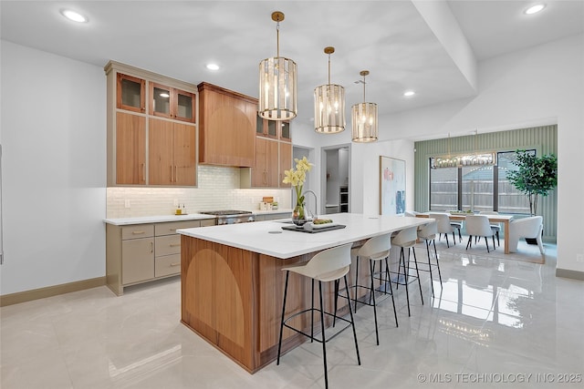 227 E 35th St, Tulsa, OK 74105 - kitchen with a chandelier, decorative backsplash, a spacious island, light countertops, and recessed lighting
