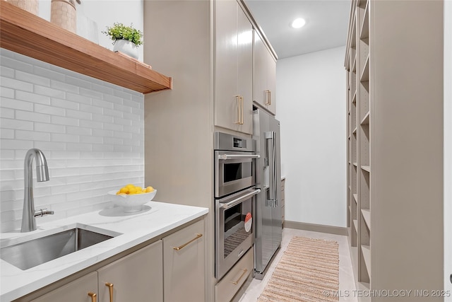 227 E 35th St, Tulsa, OK 74105 - kitchen with a sink, open shelves, appliances with stainless steel finishes, decorative backsplash, and light stone counters