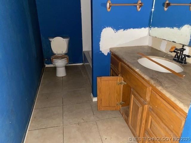 bathroom with toilet, tile patterned flooring, a tub to relax in, and vanity