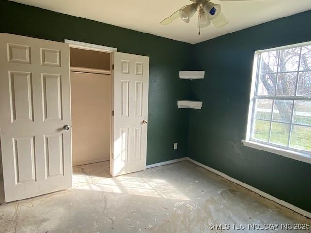 unfurnished bedroom with a closet, multiple windows, and baseboards