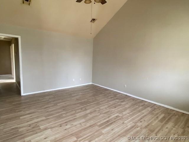 empty room featuring baseboards, visible vents, a ceiling fan, wood finished floors, and high vaulted ceiling