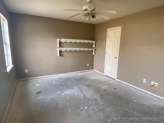 empty room with concrete floors, baseboards, and a ceiling fan