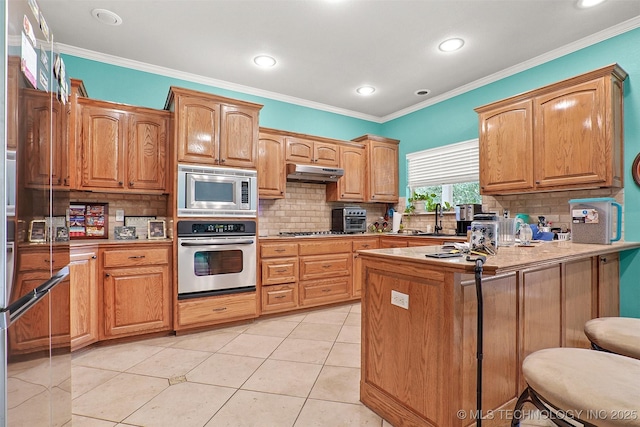 1474 S 271st W Ave, Sand Springs, OK 74063 - kitchen featuring stainless steel appliances, a peninsula, a sink, tasteful backsplash, and under cabinet range hood