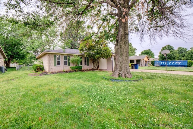 single story home with central AC unit, brick siding, a front yard, and fence