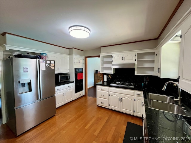 kitchen with a sink, white cabinets, appliances with stainless steel finishes, open shelves, and dark countertops