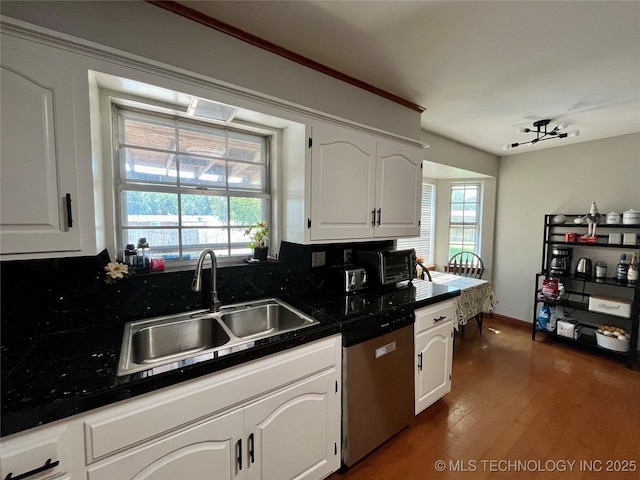 kitchen featuring stainless steel dishwasher, a healthy amount of sunlight, a sink, and white cabinets