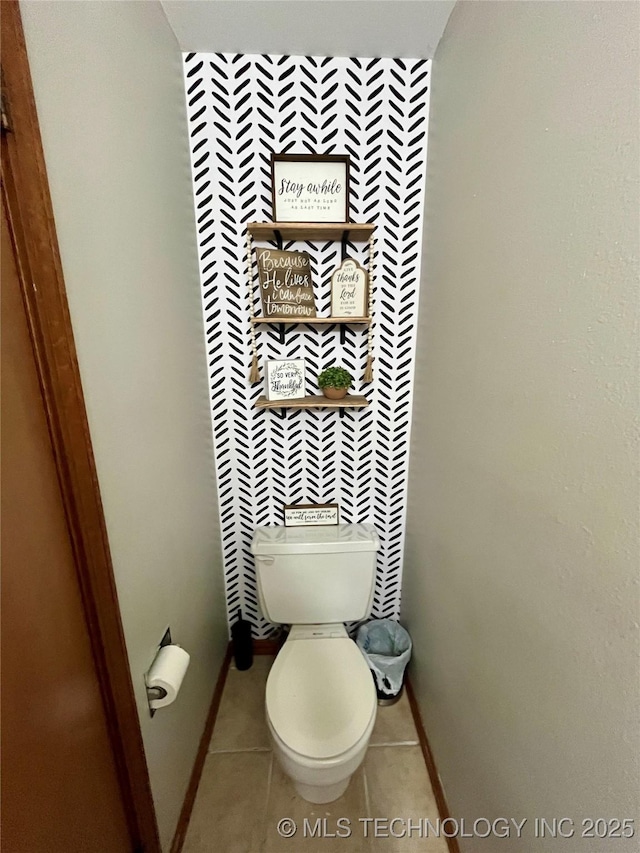 bathroom with baseboards, toilet, and tile patterned floors