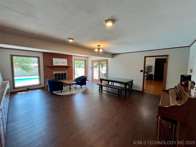 living room featuring dark wood-style floors, french doors, a textured ceiling, and a fireplace