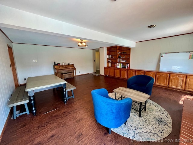 living area featuring dark wood-style floors, baseboards, and ornamental molding