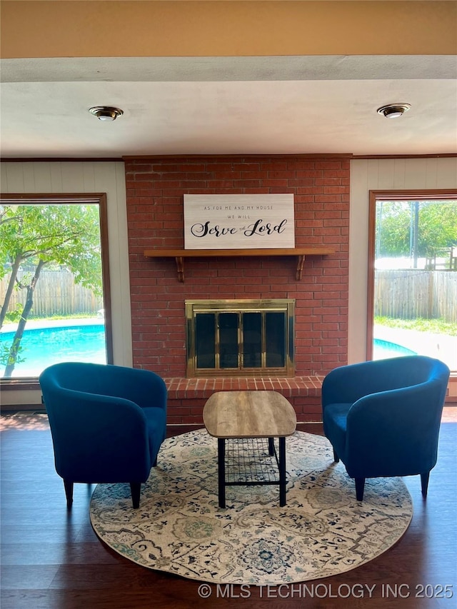 living room with a fireplace, wood walls, and wood finished floors