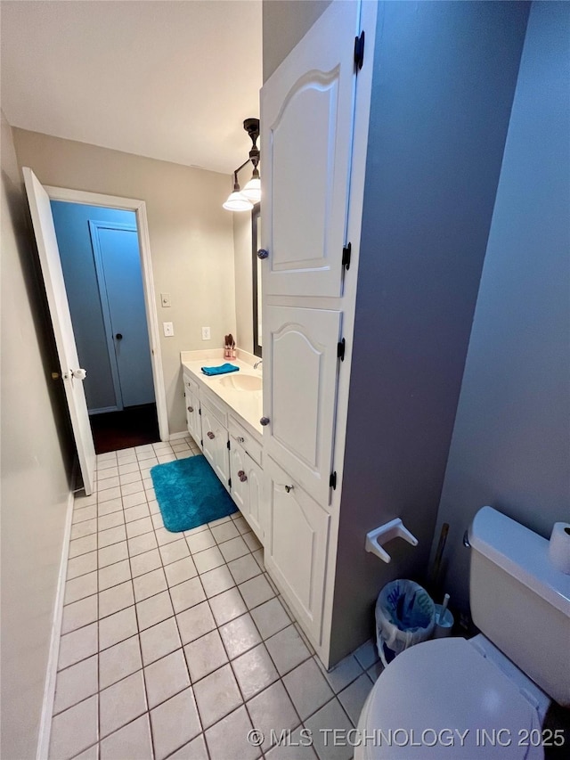 bathroom featuring tile patterned flooring, a sink, toilet, and double vanity