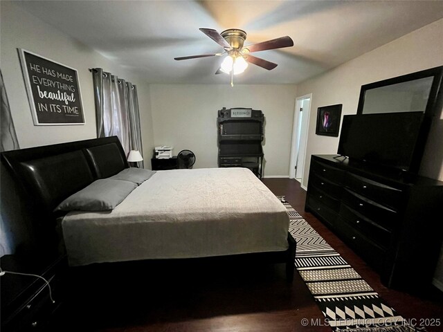 bedroom with ceiling fan and dark wood finished floors