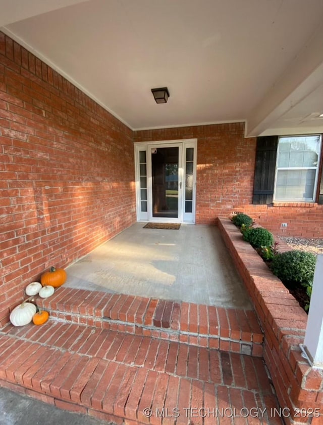 view of exterior entry featuring brick siding