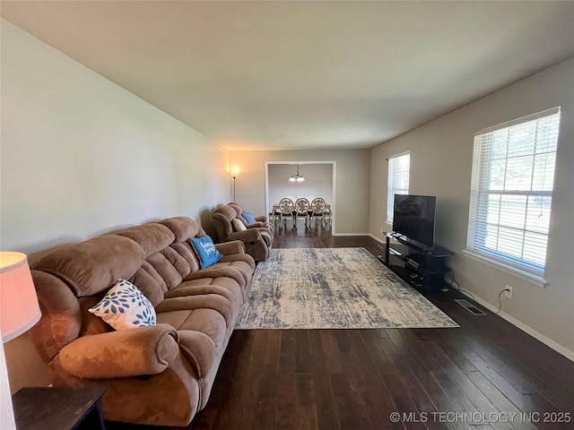 living room featuring dark wood-style floors, visible vents, and baseboards