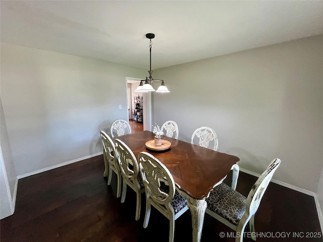 dining space with baseboards and dark wood-type flooring