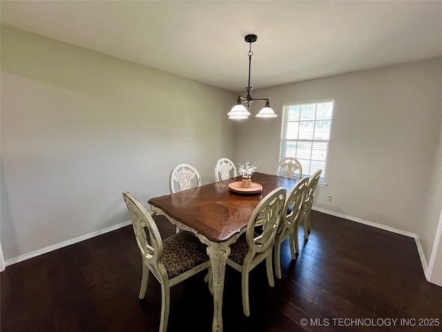 dining room with a chandelier, wood finished floors, and baseboards