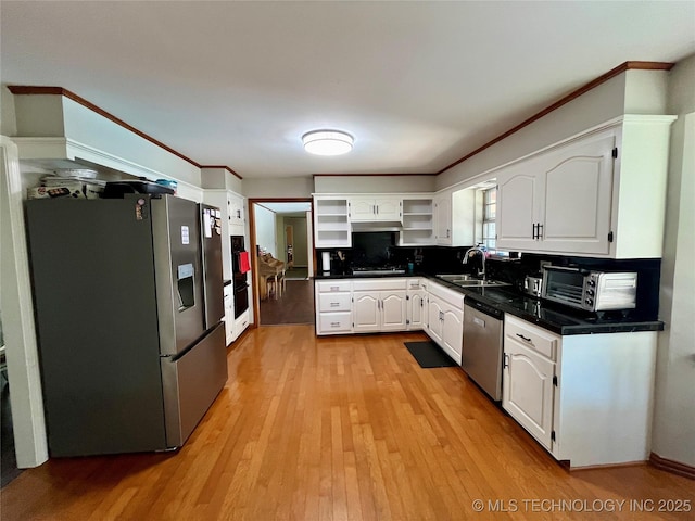 kitchen featuring dark countertops, stainless steel appliances, white cabinetry, open shelves, and a sink