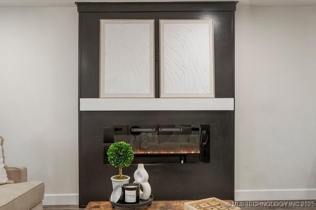 room details featuring a large fireplace and baseboards