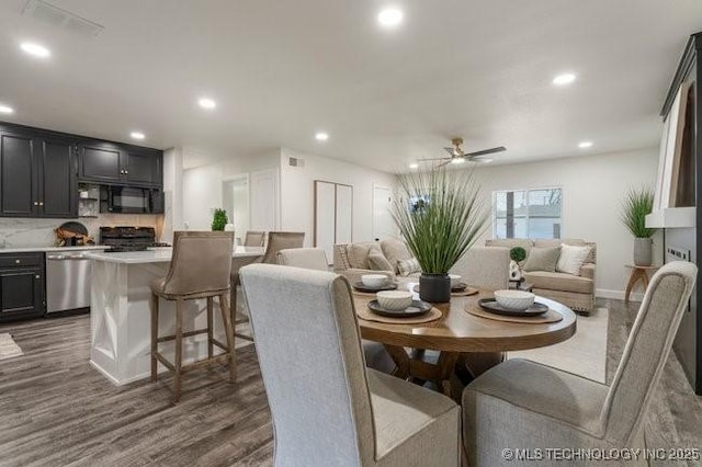 dining room featuring dark wood-style floors, a ceiling fan, visible vents, and recessed lighting