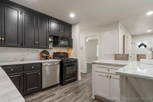 kitchen featuring decorative backsplash, dark cabinets, wood finished floors, black appliances, and recessed lighting