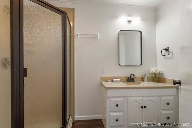 bathroom with ornamental molding, a stall shower, vanity, and baseboards