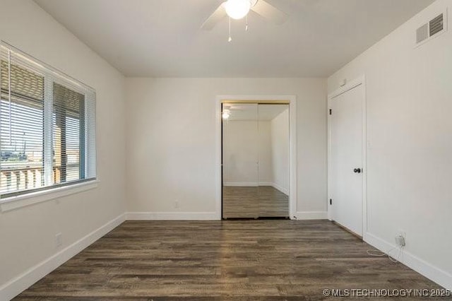 unfurnished bedroom with baseboards, a closet, visible vents, and wood finished floors