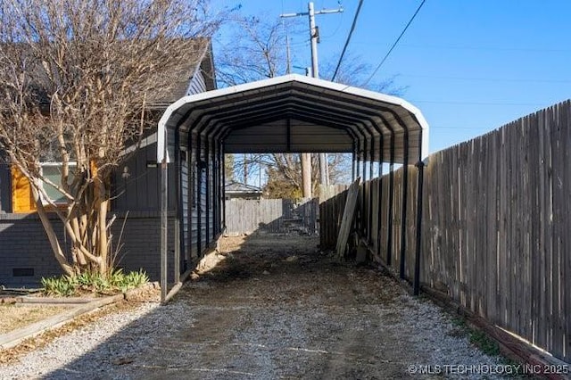 view of parking with a carport and fence