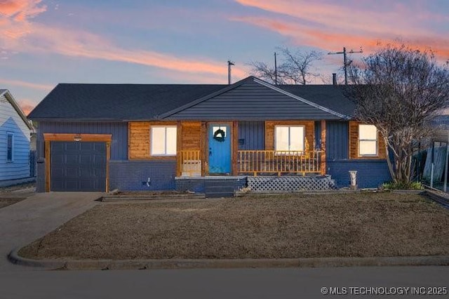 ranch-style house with a garage, driveway, brick siding, and covered porch