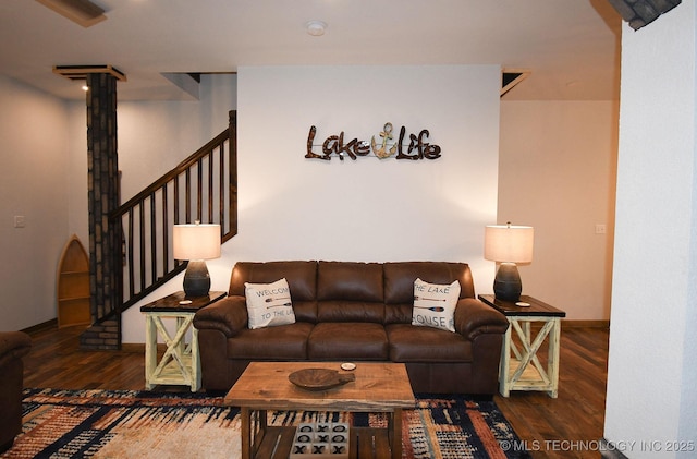 living room featuring stairs, wood finished floors, and baseboards