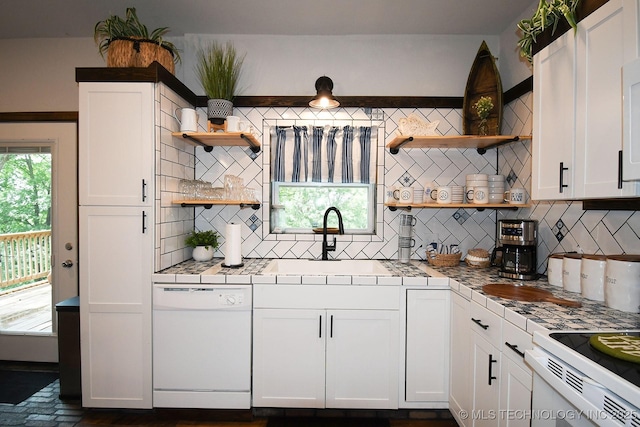 kitchen featuring a sink, tile counters, open shelves, and dishwasher