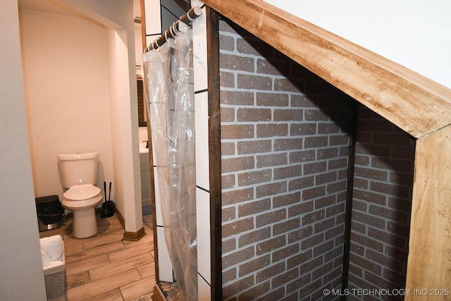 bathroom featuring wood finished floors and toilet