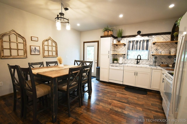 dining room featuring a chandelier, dark wood finished floors, a wealth of natural light, and recessed lighting