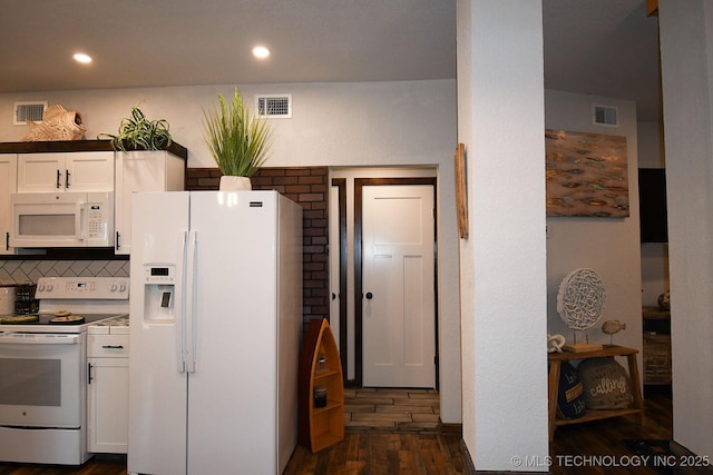 kitchen featuring white appliances, dark wood-type flooring, visible vents, and white cabinetry