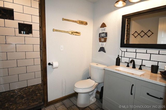 full bath featuring tasteful backsplash, toilet, vanity, wood finished floors, and tiled shower