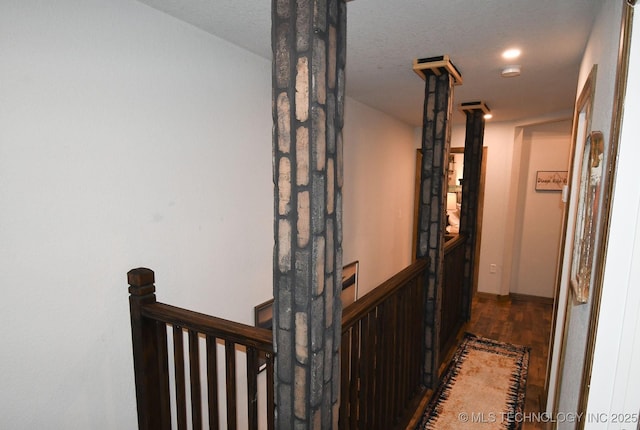 corridor featuring wood finished floors and an upstairs landing