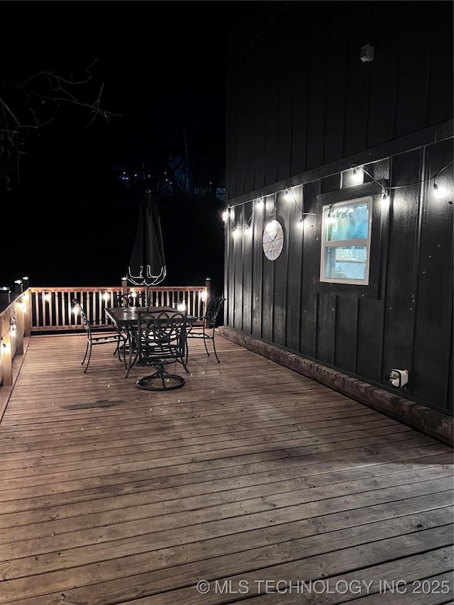 deck at twilight with outdoor dining space