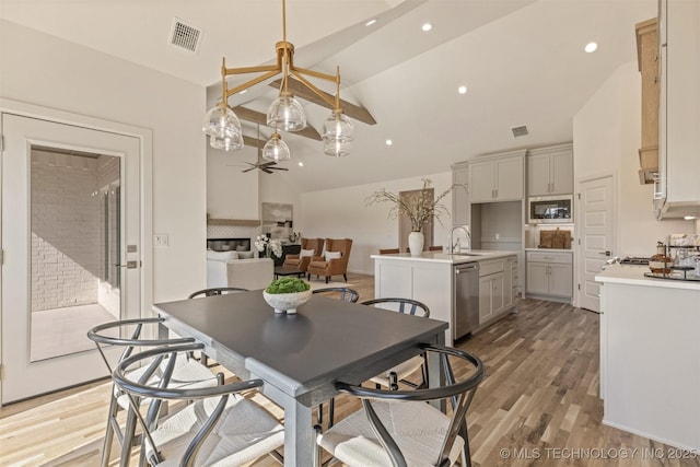 dining area featuring visible vents, light wood-type flooring, and a ceiling fan