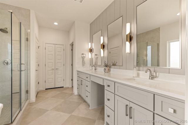 bathroom featuring a stall shower and a sink